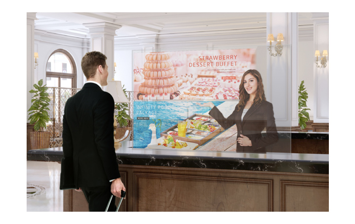 A man is getting information through the Transparent OLED screen showing photos of the dessert menu.