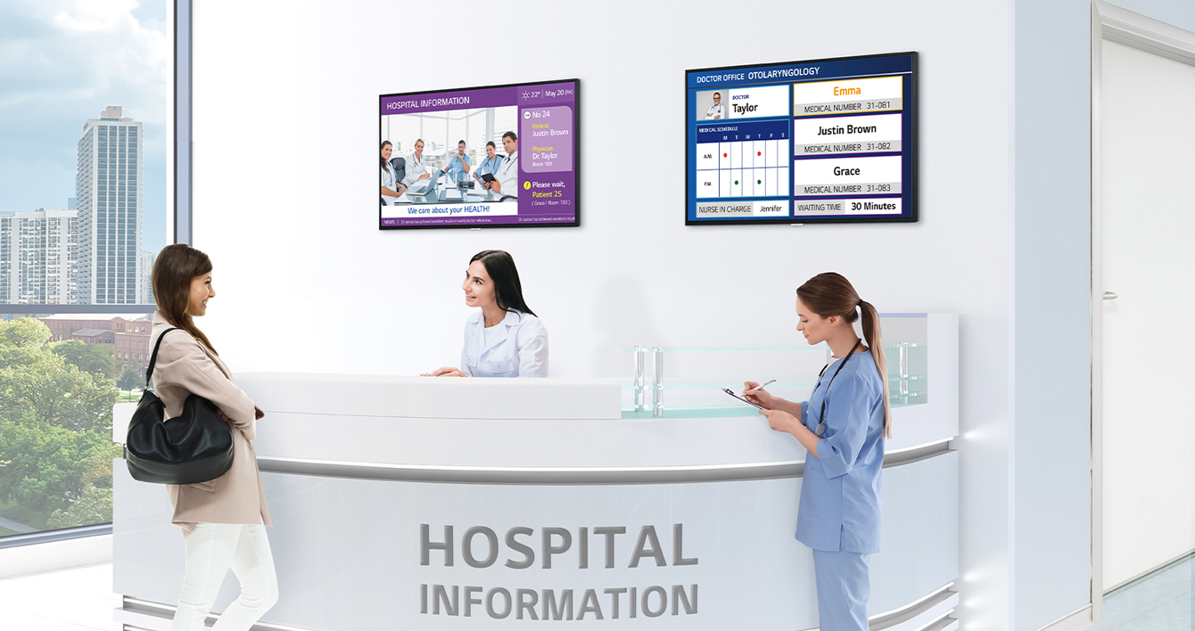 Two TVs are installed on the hospital information desk’s wall, and each screen is displaying the hospital and doctors’ information.