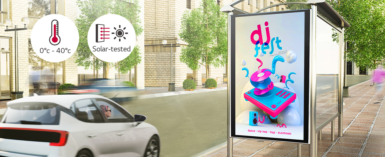 A woman in a car is looking at a DOOH (Digital Out Of Home media) ad on the side of the road. Via a solar test conducted inside LG, this product can operate at wide range of temperature of 0 to 40 degrees.